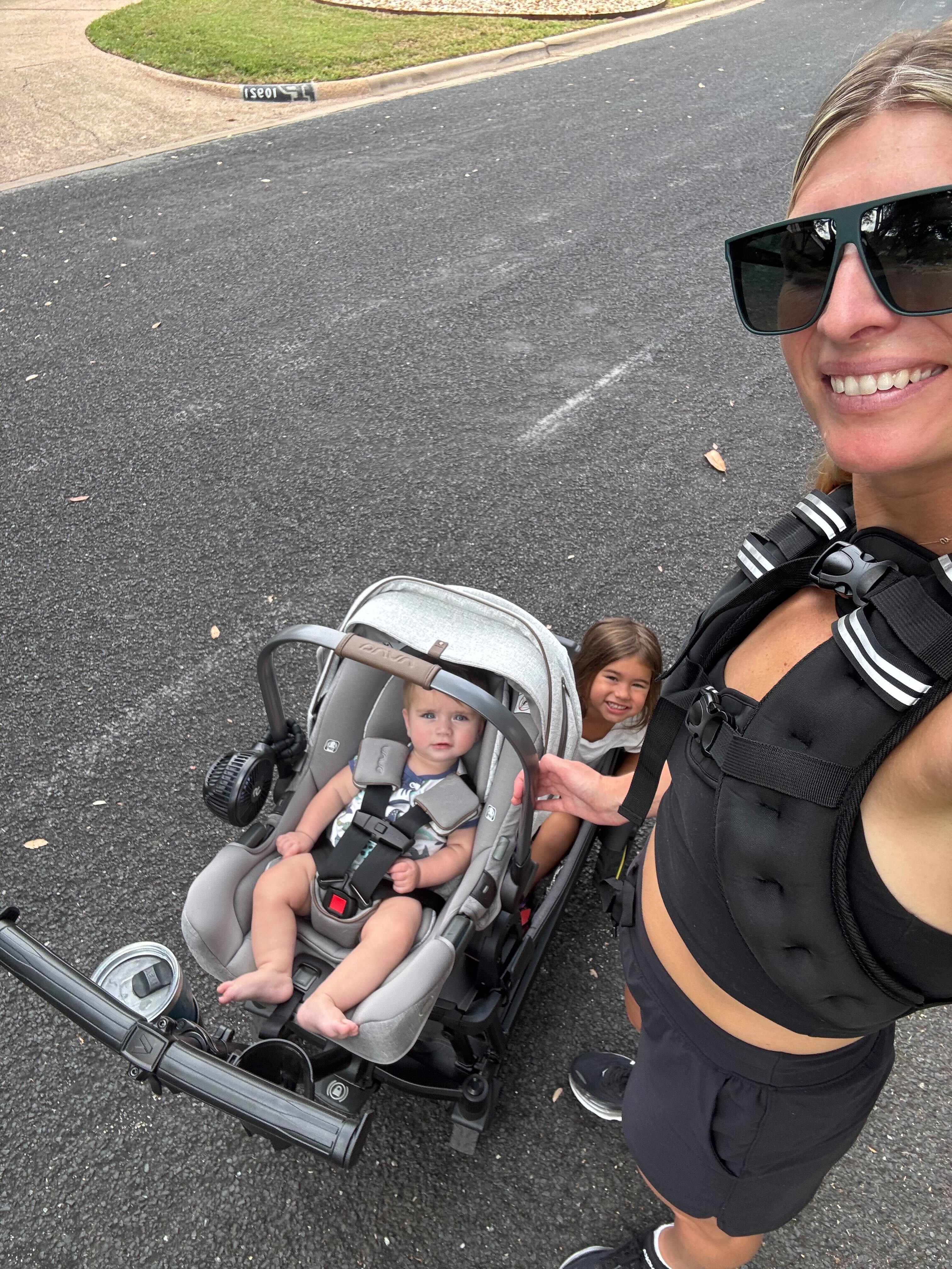 Ari walking outdoors with her children while wearing the Muther Rucker weighted vest.